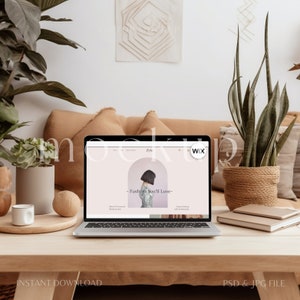 May include: A laptop computer mockup on a wooden table with a light brown couch in the background. The laptop screen displays a website with the text "Fashion You'll Love" and the Wix logo. There are plants, a cup, and a notebook on the table.