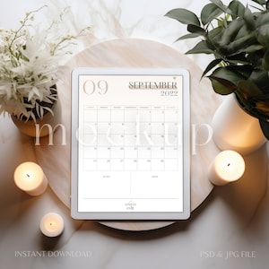 May include: A white tablet displaying a September 2022 calendar on a wooden tray with candles and plants. The calendar has the text "09 September 2022" at the top and the days of the week listed below. The calendar also has a "To Do" and "Note" section at the bottom.
