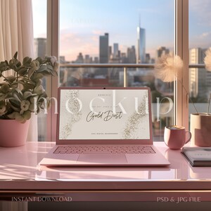 May include: A pink laptop computer with a gold glitter background on the screen. The screen displays the text "Gold Dust" and "Chic Digital Backgrounds". The laptop is on a pink desk with a pink plant, a pink mug, and a book.