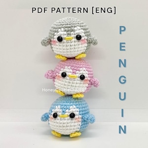 May include: Three crocheted penguin toys stacked on top of each other. The top penguin is gray, the middle one is pink, and the bottom one is blue. Each has a white belly, black eyes, yellow beak and feet, and small wings. Text on the image reads "PDF PATTERN [ENG] PENGUIN".