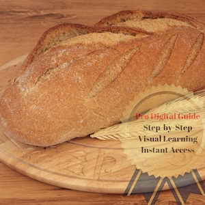 Könnte beinhalten: Ein Laib knuspriges Brot auf einem Holzbrett mit einem Weizenhalm und einem gelben und schwarzen Band mit dem Text "Pro Digital Guide - Step by Step Visual Learning - Instant Access".