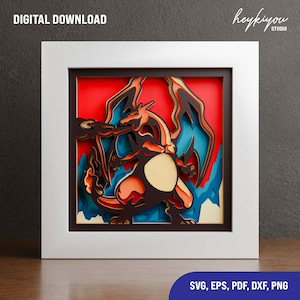 Könnte beinhalten: Gerahmtes, geschichtetes Papierkunstwerk mit einem Charizard-Design. Das Kunstwerk verwendet Orange-, Schwarz- und Blautöne vor einem roten Hintergrund. Der Rahmen ist weiß, und die Worte "DIGITAL DOWNLOAD" stehen oben links.