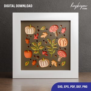 May include: A framed autumn-themed digital download featuring pumpkins, mushrooms, and leaves in shades of orange, red, and green. The artwork is set against a brown background and includes the text "DIGITAL DOWNLOAD" and "SVG, EPS, PDF, DXF, PNG".
