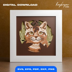 May include: A layered paper art piece featuring a cat's face with green eyes and brown fur, set against a backdrop of brown and green tones. The artwork is framed in a white square and includes the text "DIGITAL DOWNLOAD" and "SVG, EPS, PDF, DXF, PNG".