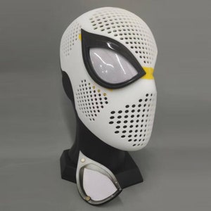 May include: White and black Spider-Man mask with a black spider design and a white mesh covering the face. The mask is on a black stand.