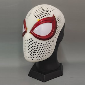 May include: White and red Spider-Man mask with a mesh design. The mask has a red spider design on the front and a mesh covering the entire mask.