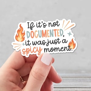 May include: A die-cut sticker featuring the text "If it's not DOCUMENTED, it was just a spicy moment." The design includes orange flame illustrations, small teal stars, and light orange radiating lines on a white background with a thin white border.