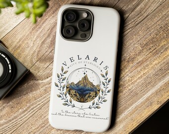 May include: White phone case with a graphic of a mountain range inside a circle with the text "VELARIS CITY OF STARLIGHT" and the quote "To the stars we listen and the dreams that are answered".
