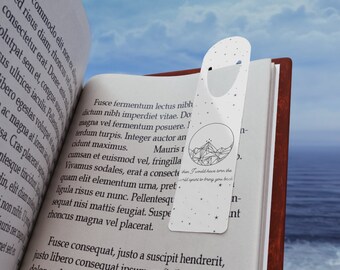 May include: A white bookmark with a geometric mountain design and stars. The bookmark has a quote: "Then I would have torn the world apart to bring you back."