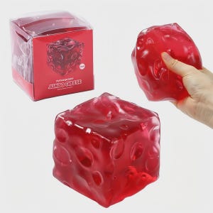 May include: A translucent red cube-shaped squishy toy with a dimpled surface, resembling cheese. The toy is shown both inside its red box and held in a hand. The box has the text "FUFUSQUISHY JUMBO CHEESE".