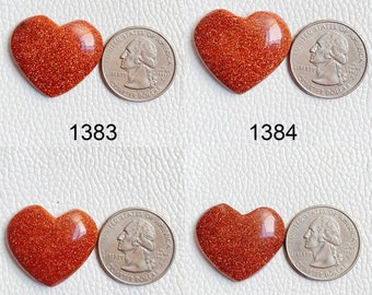 May include: Four heart-shaped red sandstone cabochons, each about the size of a US quarter. The cabochons are smooth and polished, with a sparkly, glittery texture.
