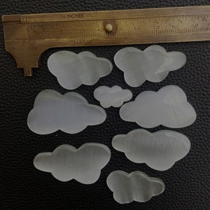 May include: A set of seven white selenite crystal clouds and butterflies. The crystals are smooth and have a slightly iridescent sheen.