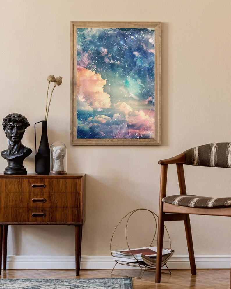 Op de afbeelding: Een ingelijste kunstdruk met een dromerige luchtsc&egrave;ne met wolken in roze, blauw en wit. Het kunstwerk wordt tentoongesteld boven een houten kast met een zwart buste, een zwarte vaas en een glazen koepel. Een houten stoel en een metalen tijdschriftenrek zijn ook zichtbaar.