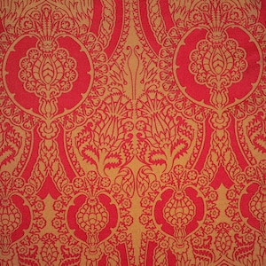 K&ouml;nnte beinhalten: Roter Stoff mit einem goldenen Muster aus stilisierten Blumen und Bl&auml;ttern.