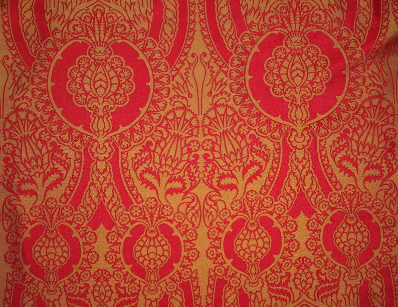 K&ouml;nnte beinhalten: Roter Stoff mit einem goldenen Muster aus stilisierten Blumen und Bl&auml;ttern.