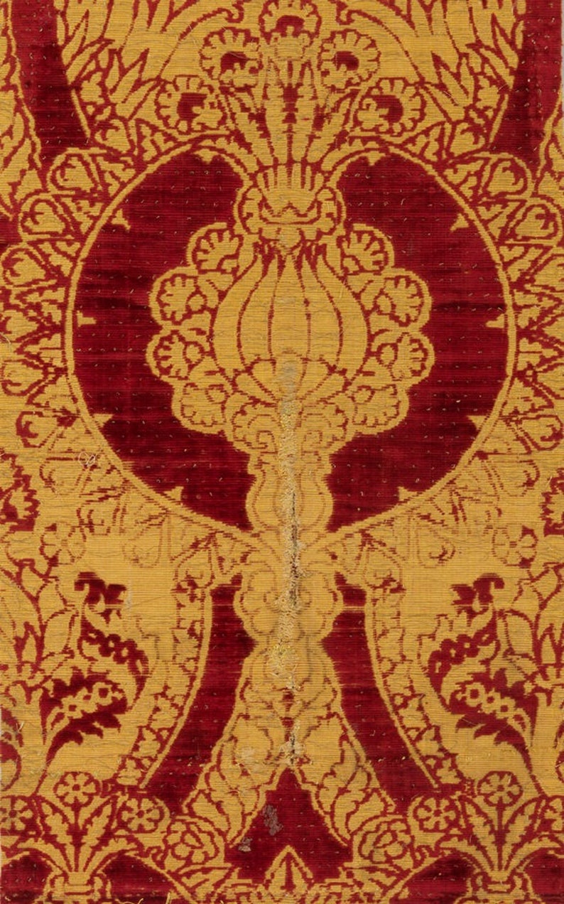 K&ouml;nnte beinhalten: Nahaufnahme eines roten und goldenen Stoffes mit einem sich wiederholenden Muster aus stilisierten Blumen und Bl&auml;ttern. Der Stoff hat eine reiche, strukturierte Optik und Haptik.