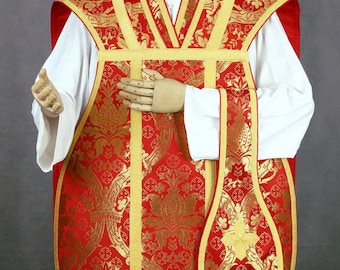 Może przedstawiać: Czerwona i złota szata liturgiczna ze skomplikowanymi wzorami kwiatowymi. Szata posiada złote wykończenia i pasującą stułę. Odzież jest prezentowana na manekinie, prezentując jej design i kunszt.