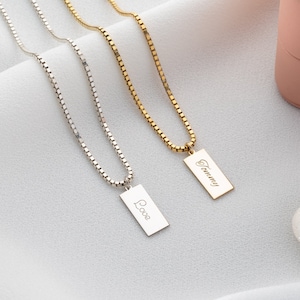 Peut inclure: Trois chaînes en argent avec des pendentifs rectangulaires. Les pendentifs sont gravés avec les mots "Love" et "Tommy".