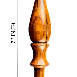 May include: A 7-inch wooden crochet hook with a polished finish. The hook features a rounded handle and a curved hook end, ideal for yarn crafts. The wood grain is visible, adding to its natural aesthetic.