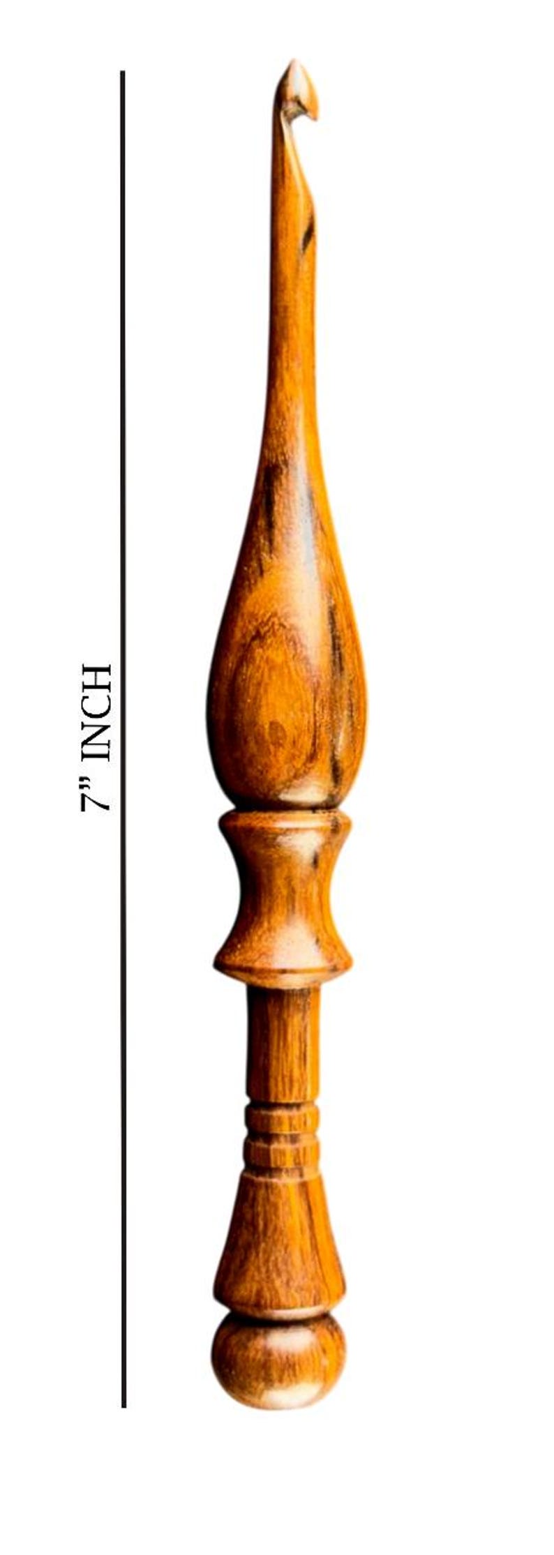 May include: A 7-inch wooden crochet hook with a polished finish. The hook features a rounded handle and a curved hook end, ideal for yarn crafts. The wood grain is visible, adding to its natural aesthetic.