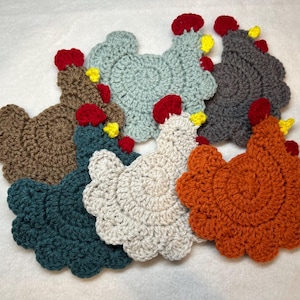 May include: Six crocheted chicken-shaped coasters in various colors, including brown, teal, white, gray, and orange.