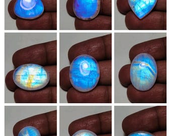 May include: Assortment of nine rainbow moonstone cabochons in various shapes and sizes. The stones are translucent and display a range of iridescent colors, including blue, green, and yellow.