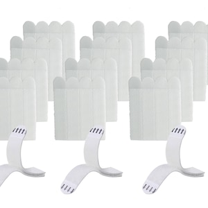 May include: A selection of white adhesive strips and mounting tabs. The strips have a textured surface and a scalloped top edge. The mounting tabs are curved and have small, pointed adhesive tips. The items are arranged against a white background.