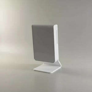 May include: A contemporary white and grey electronic device with a curved top and a rectangular screen. The device has a sleek design, standing upright on a white base. The grey screen contrasts with the white frame, creating a modern aesthetic.