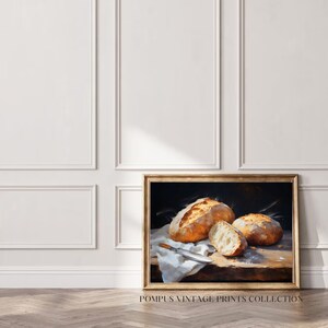 May include: A painting of three loaves of bread on a wooden table with a white cloth and a knife. The bread is golden brown and crusty. The background is dark.