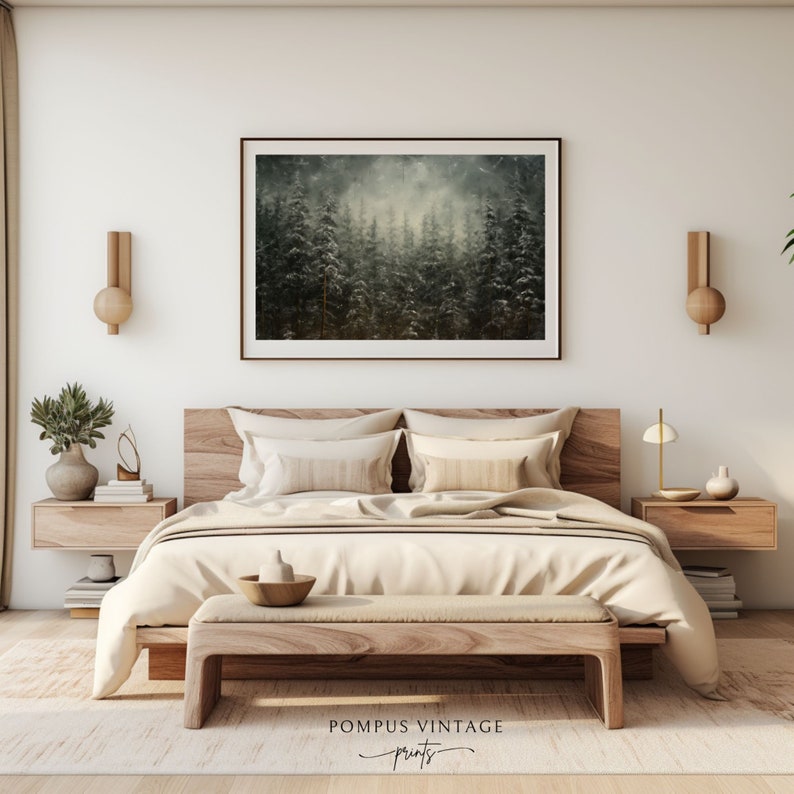 May include: A bedroom interior with a wooden bed frame and a beige duvet. The bed has two pillows and a wooden bench at the foot of the bed. There is a framed print of a foggy forest scene hanging on the wall above the bed. The room has a minimalist aesthetic with wooden nightstands and wall sconces.