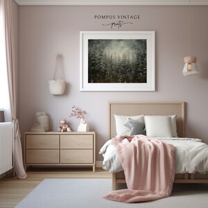 May include: A framed print of a misty forest scene with tall, dark green trees. The print is hanging on a light pink wall in a bedroom with a wooden dresser and a bed with a pink blanket.