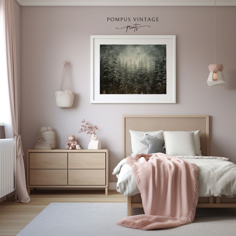 May include: A framed print of a misty forest scene with tall, dark green trees. The print is hanging on a light pink wall in a bedroom with a wooden dresser and a bed with a pink blanket.