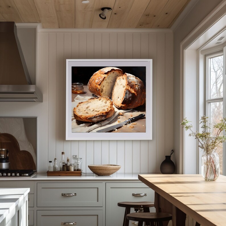 May include: A framed painting of a still life featuring a loaf of freshly baked bread sliced open, revealing the soft, golden interior. The bread is arranged on a white cloth with a knife nearby, creating a simple yet elegant composition.