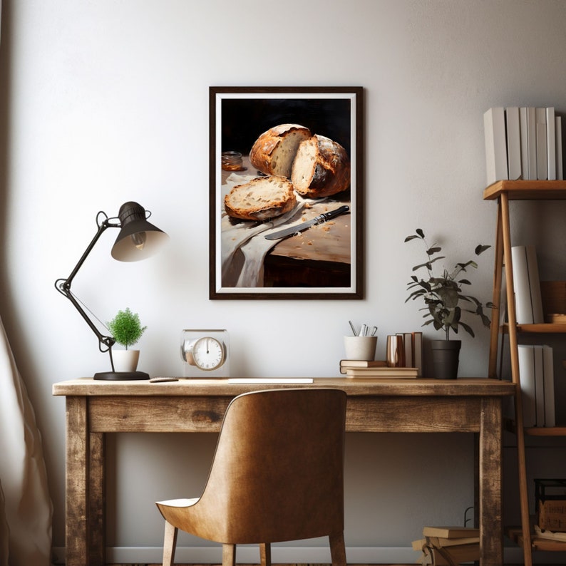 May include: A framed painting of a still life featuring a loaf of bread sliced in half, a knife, and a small jar on a wooden table with a white cloth.