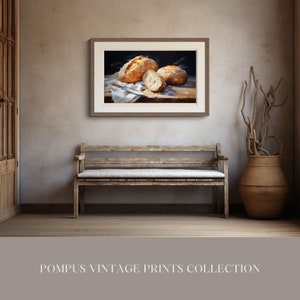 May include: A framed painting of three loaves of bread on a white cloth. The bread is golden brown and has a rustic appearance. The painting is set against a dark background.