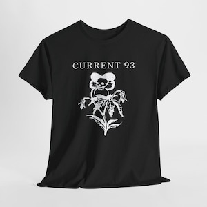 Puede incluir: Una camiseta negra de manga corta con un estampado gráfico blanco en el pecho. El diseño muestra el texto CURRENT 93 sobre una ilustración estilizada de una flor con una calavera en el centro, realizada en un estilo de tinta blanca desgastada.