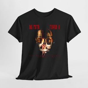 Puede incluir: Una camiseta negra de manga corta con un estampado gráfico de un rostro humano superpuesto con rayas horizontales y una línea roja garabateada. El texto "DIG FORM" y "RAYON X" está impreso en rojo sobre el rostro, con más texto debajo.