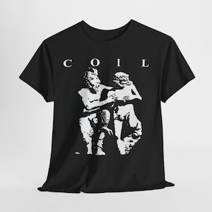 Puede incluir: Una camiseta negra de manga corta con un estampado gráfico blanco de dos figuras de estilo clásico y el texto COIL centrado sobre la imagen. El diseño está representado en un estilo de plantilla de alto contraste en la parte frontal.