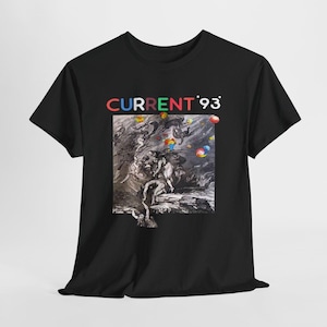 Puede incluir: Una camiseta negra de manga corta con el texto CURRENT 93 en letras multicolores sobre un gráfico cuadrado. El gráfico muestra una ilustración clásica en blanco y negro de figuras en un paisaje, acentuada con pequeñas esferas coloridas flotantes.