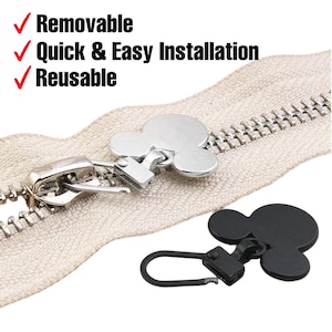 Może przedstawiać: Zbliżenie beżowego zamka błyskawicznego z srebrnym uchwytem zamka błyskawicznego w kształcie Myszki Miki. Czarny uchwyt zamka błyskawicznego w kształcie Myszki Miki pokazano osobno. Tekst na zdjęciu brzmi: Zdejmowany, Szybka i łatwa instalacja, Wielokrotnego użytku.