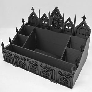 May include: A black desk organizer with a gothic cathedral design. The organizer has multiple compartments and is decorated with arched windows, crosses, and a rose window. The overall design is reminiscent of a church or cathedral.