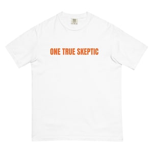May include: White t-shirt with the orange text "ONE TRUE SKEPTIC" across the chest. The shirt has a crew neck and short sleeves. The fabric appears to be a soft, comfortable material.