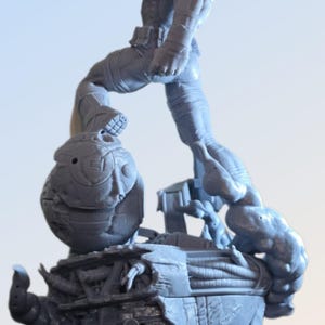 May include: A gray figurine of a muscular figure in a dynamic pose, stepping onto a detailed, futuristic base. The figure has a red accent and is surrounded by mechanical and organic elements.