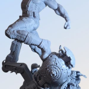 May include: A gray action figure of a superhero in a dynamic pose, leaping from a detailed, mechanical base. The figure is highly detailed, with visible muscles and costume elements. A red object is held near the face.