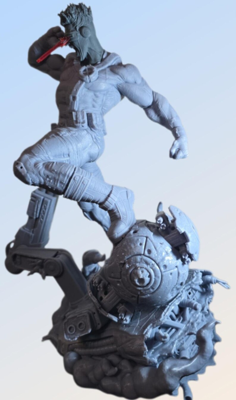 May include: A gray action figure of a superhero in a dynamic pose, leaping from a detailed, mechanical base. The figure is highly detailed, with visible muscles and costume elements. A red object is held near the face.