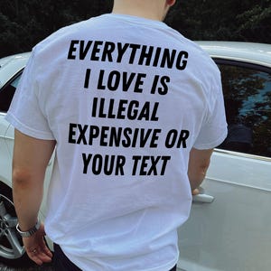 May include: White t-shirt with black text that reads "Everything I love is illegal expensive or your text".