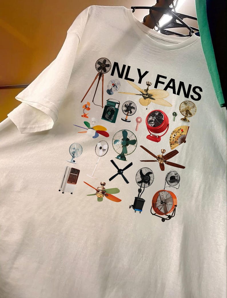 May include: White t-shirt with a graphic print of various fans and the text "ONLY FANS" in black.