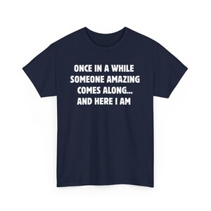 Op de afbeelding: Marineblauwe t-shirt met witte tekst: "ONCE IN A WHILE SOMEONE AMAZING COMES ALONG... AND HERE I AM." Dit t-shirt met korte mouwen en ronde hals is geschikt voor dagelijks gebruik.