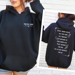 Puede incluir: Sudadera con capucha negra con el texto "PRACTICAL MAGIC" en la parte delantera y "ALWAYS THROW SPILLED SALT OVER YOUR LEFT SHOULDER KEEP ROSEMARY BY YOUR GARDEN GATE PLANT LAVENDER FOR LUCK FALL IN LOVE WHENEVER YOU CAN" en la parte trasera.