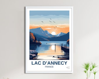 May include: A colourful illustration of a lake scene with mountains in the background. The sun is setting over the lake, and there is a small jetty in the water. The text "LAC D'ANNECY FRANCE" is at the bottom of the image.